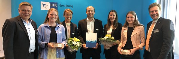 Foto aus den Schleswiger Nachrichten mit folgendem Untertitel: "Freuen sich über den Sonderpreis für die Dannewerkschule: Finn Hübner (v.li.), Clara Frischkemuth, Marieke Jebe, Kerstin Günter so- wie Aleksandra Maltusch gemeinsam mit Björn Ipsen, Hauptgeschäftsführer der IHK Flensburg."