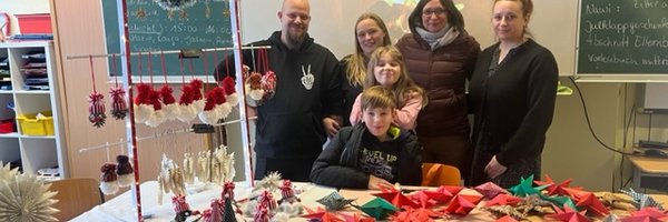 Mehrere Personen stehen hinter einem Verkaufstisch mit selbstgestalteten Adventsdekorationen.