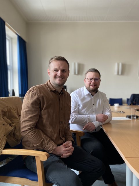 Torben Behrens und Bürgermeister Jonas Kähler sitzend im Sitzungszimmer Schlei
