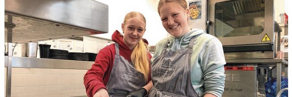 Foto von zwei gut gelaunten Schülerinnen in Küche Restaurants "Strandleben" bzgl. des Schülerdinners 20245 der Dannewerkschule Schleswig