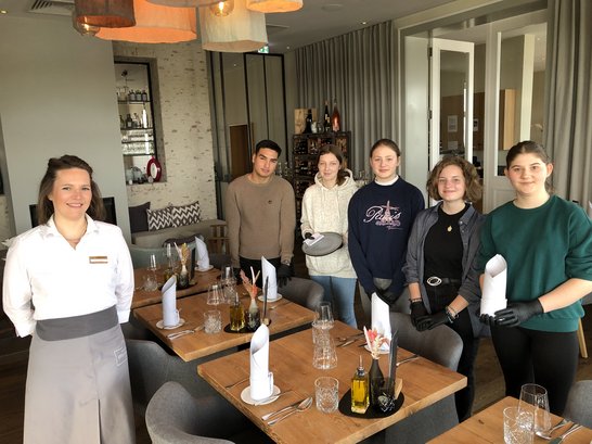 Foto Schüler*innen beim Bedienen in Restaurant