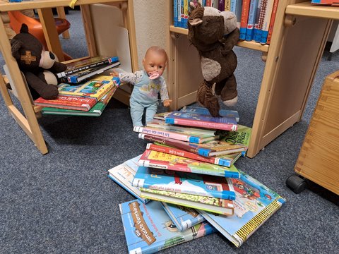 Kuscheltiere zwischen Büchern in der Stadtbücherei