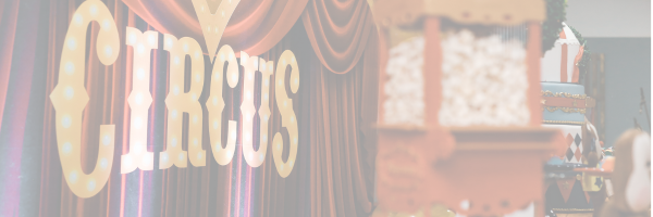 Vorhang mit den Buchstaben Circus im Vordergrund, dahinter eine alte Popcornmaschine